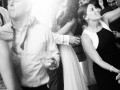 bride and groom kiss on dance floor surrounded by guests